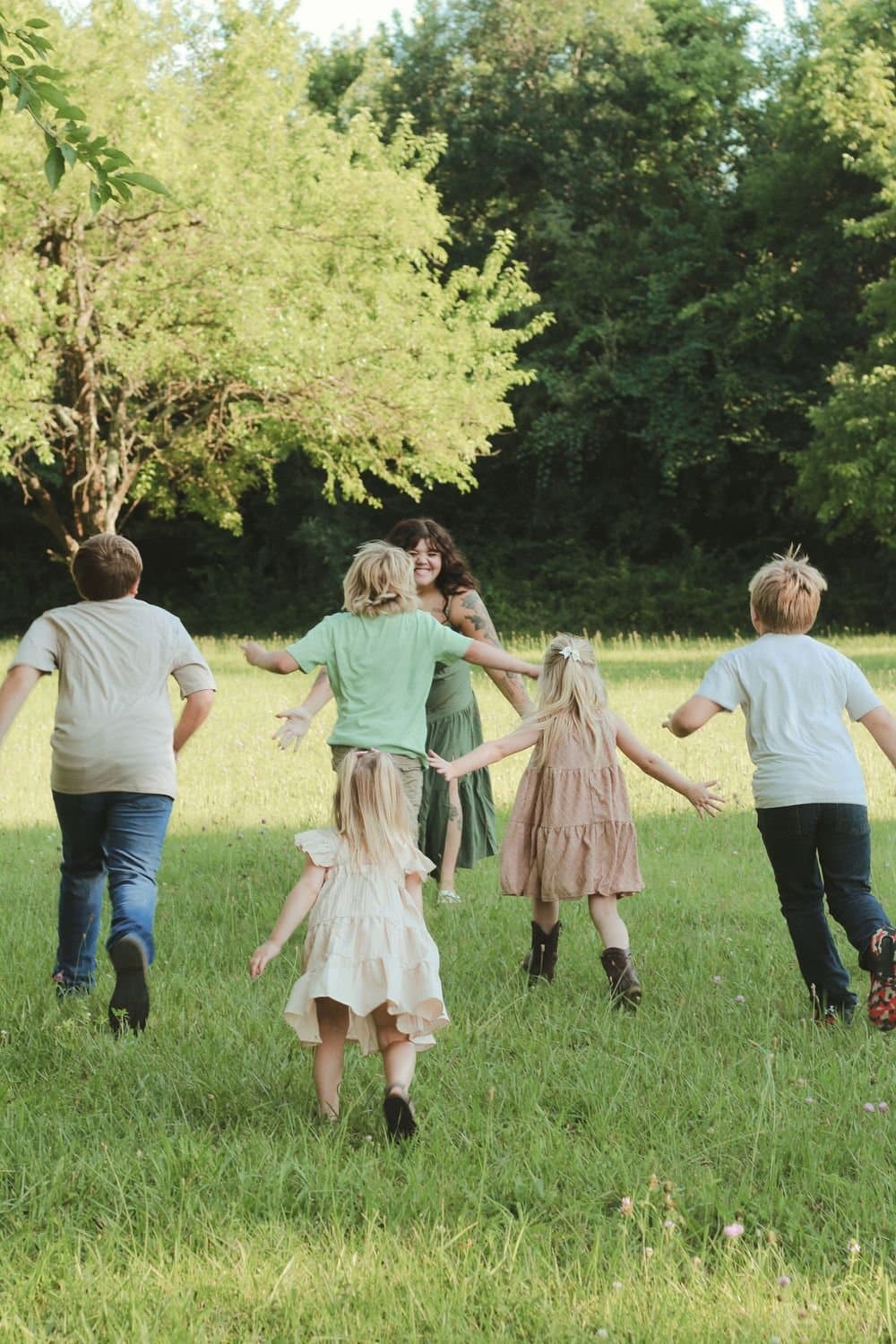 Family running hand in hand through a field