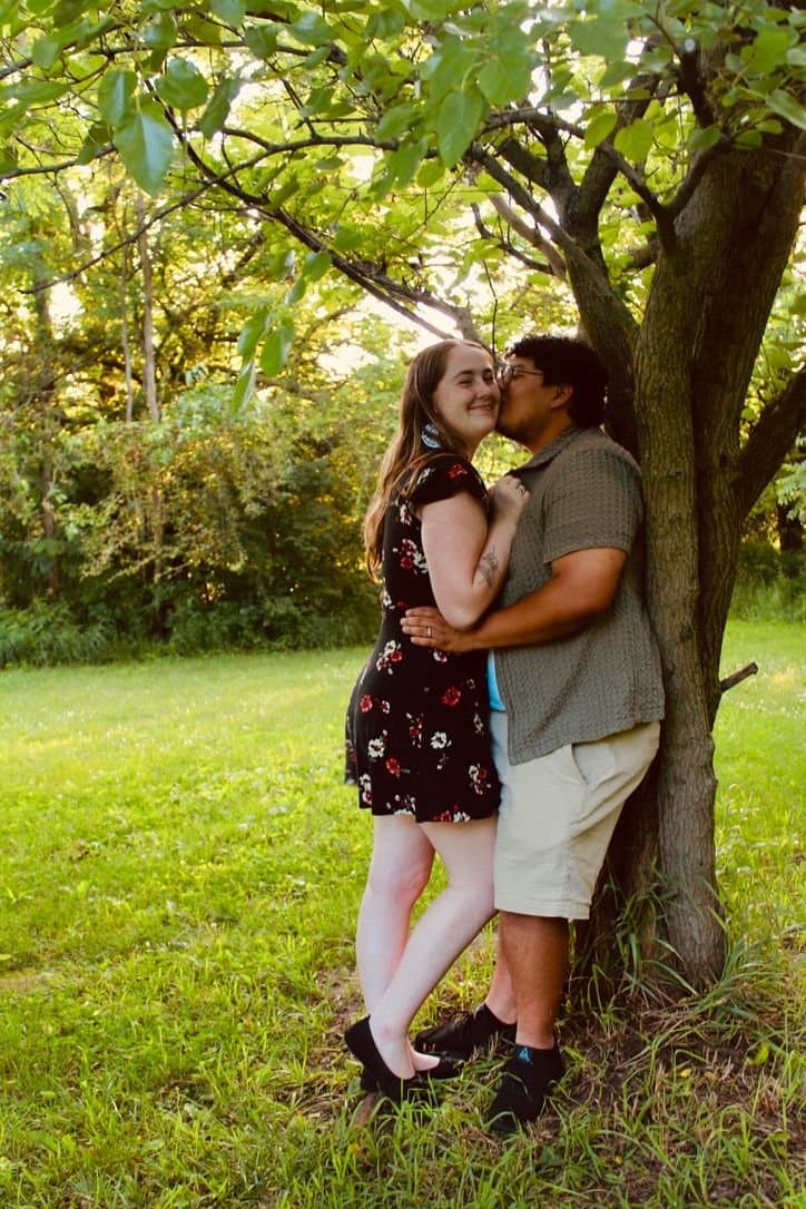 Couple sharing a kiss under a big tree