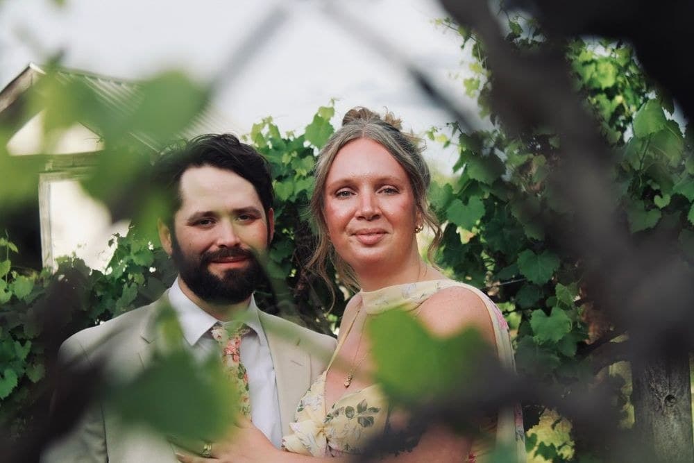 Couple framed by vine leaves at a formal session